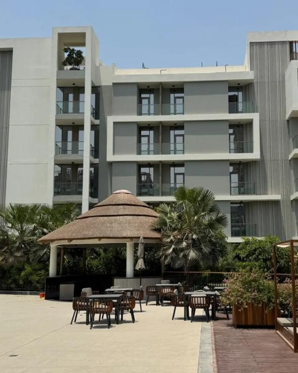 Torino buildings with timber-slatted balconies above the pool deck and thatched gazebo